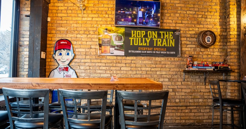 Bar table, stools, tv screen on the wall behind