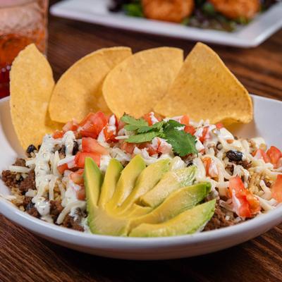 Southwest Chorizo Bowl topped with avocado, jalapeño aioli drizzle and tortilla chips.