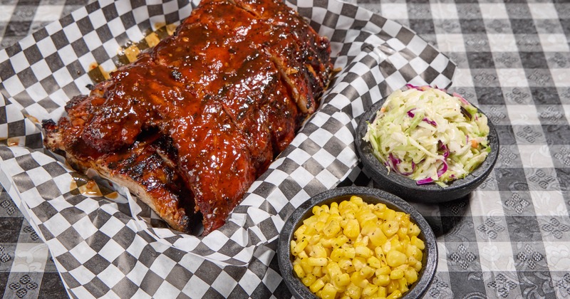 Barbecue ribs served with coleslaw and sweet corn