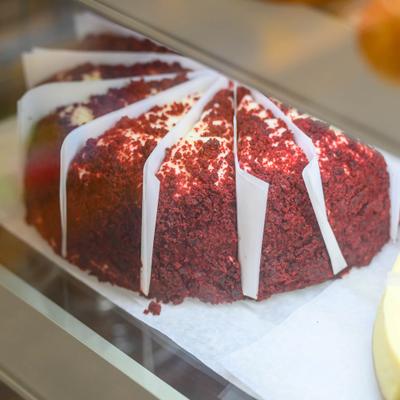 Red Velvet Cheesecake served pre-sliced inside a displayed case.