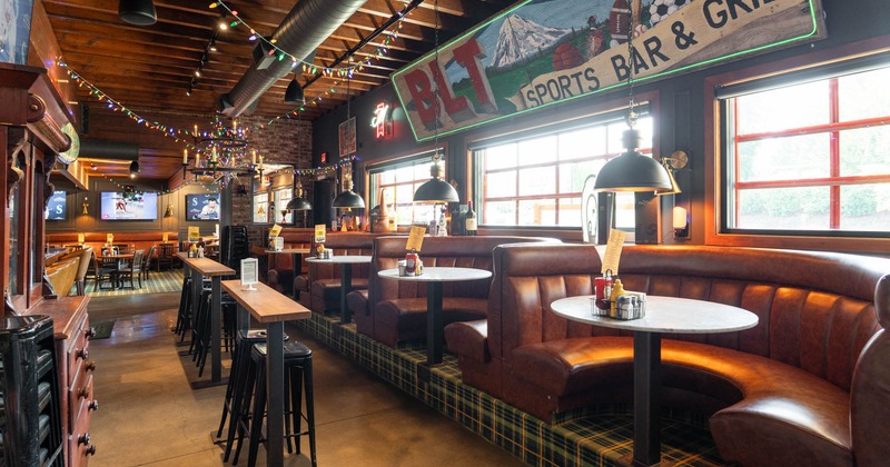 Interior, sports bar, cozy leather booths, wooden tables and pendant lighting