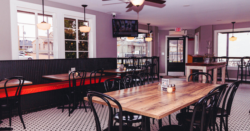 Interior, a long wooden table with benches, tables and chairs in the back