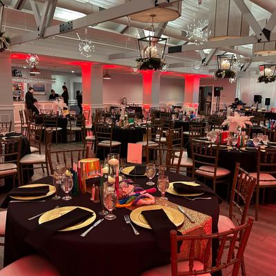 Fully set tables with black tablecloth.