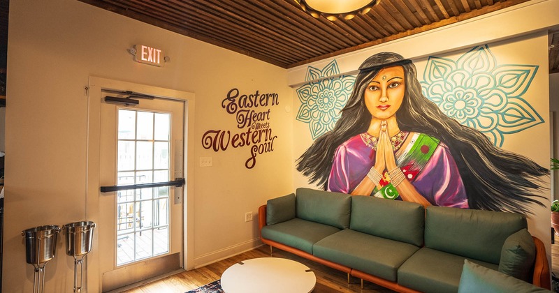 Interior, large sofa, corner seating, large Indian motif mural, writing on the wall