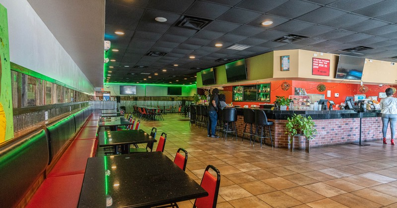 Interior, bar and order counter, banquette seating by a wall, tables and seats