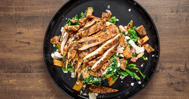 Grilled chicken salad with broccoli rabe, cheese crumbles, potatoes, and onion