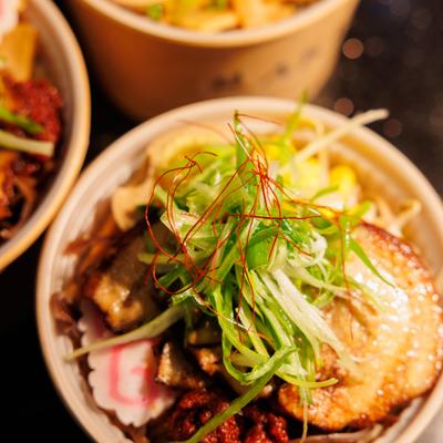 Various rice bowls served in paper containers.