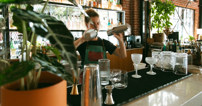 Bar, employee, mixing drinks, drink rack behind