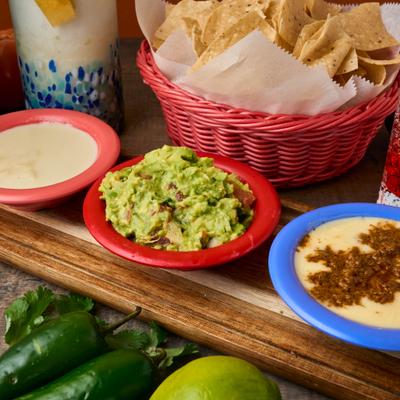 Tortilla chips served with cheese dip, guacamole, and queso chorizo dip.
