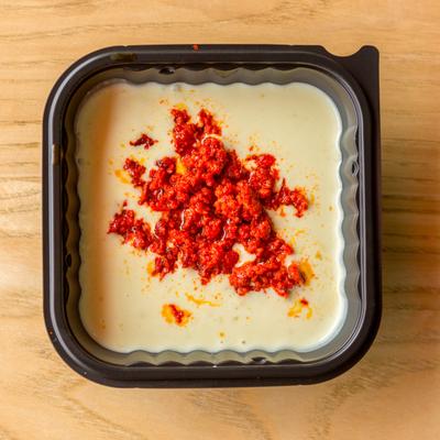 Burritos smothered in cheese and topped with chorizo.