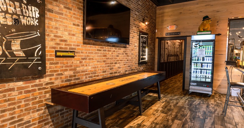 Interior, shuffleboard by a wall with decorations and TV