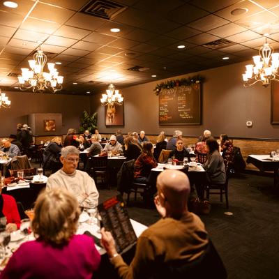 Dining room with several groups of people seated at tables.