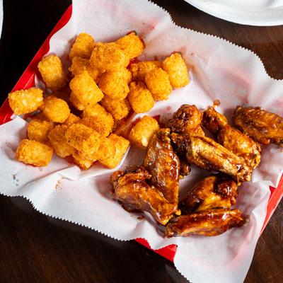 Fried chicken wings with tater tots.