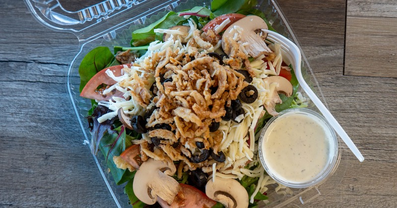 Salad with spring mix, mozzarella, tomatoes, mushrooms, olives, and crispy onions
