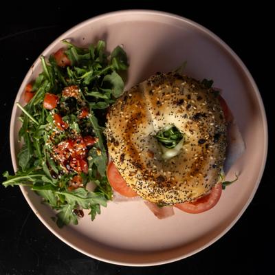 Ham and cheese bagel on the plate.