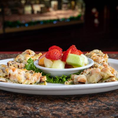 Chicken Pesto Flatbread served with a side of fresh fruit.