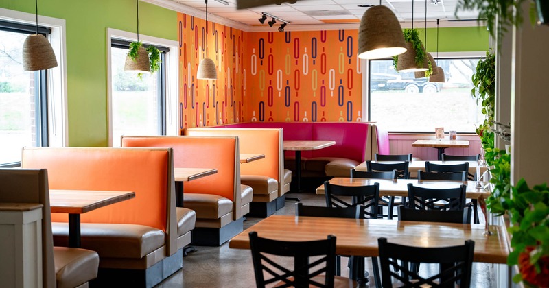 Interior, sating booths padded in orange leather with tables, regular tables with chairs