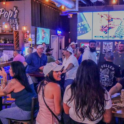 Guests enjoying drinks in a lively bar.