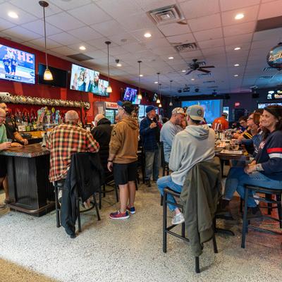 Interior with people seating at the bar and tables.