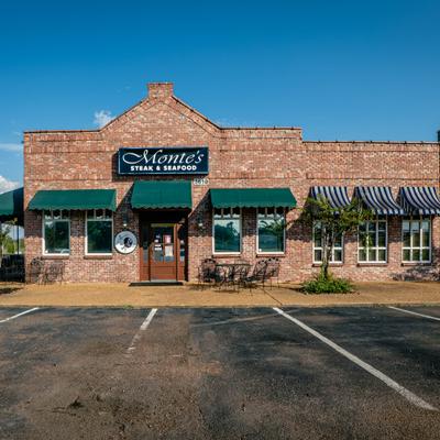 Exterior with entrance, sign and different styles of awnings.