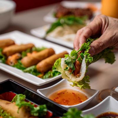 Customer dipping a bun in sauce.
