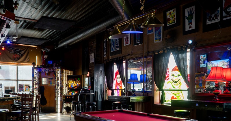 Interior, eclectic bar area with red pool table and colorful lights