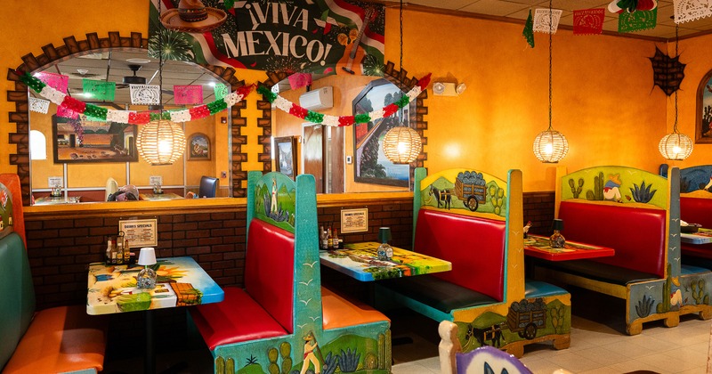 Vivid and cozy Mexican-style interior dining area with colorful dining booths along the wall