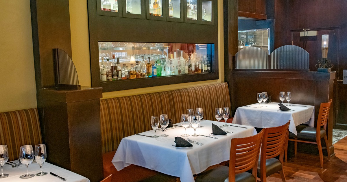 Interior, dining area, fully set tables, liquor bottles in the background