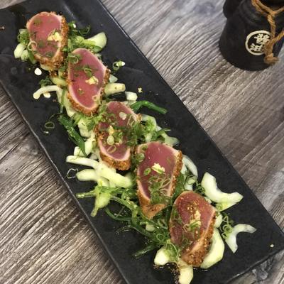 Seared sesame crusted ahi tuna, with scallions, seaweed, cucumber, and ponzu sauce.