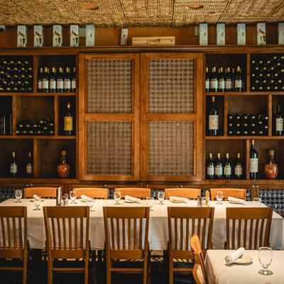 Interior with a table set for guests and a wine cabinet backdrop.