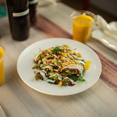Samosa chaat accompanied by a cup of mango lassi.