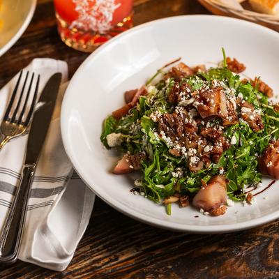 A salad with Asian pears, arugula, candied walnuts, and gorgonzola cheese.