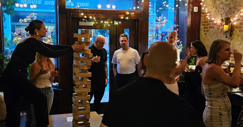 Interior, dining area, guest playing giant Jenga