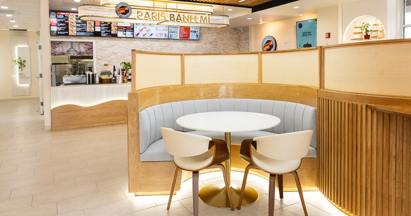 Modern and cozy interior space, a half-round upholstered booth, and an order counter behind