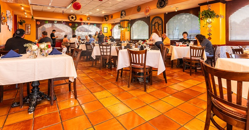 Interior, dining area with set tables, guests enjoying their food and drinks