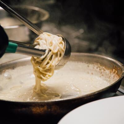 Employee preparing spaghetti in the kitchen