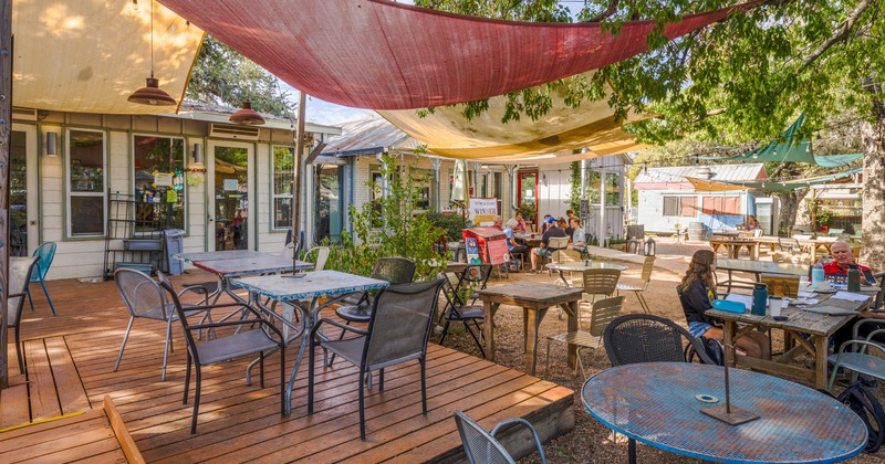 Exterior, patio, seating area under trees and sun shade sails