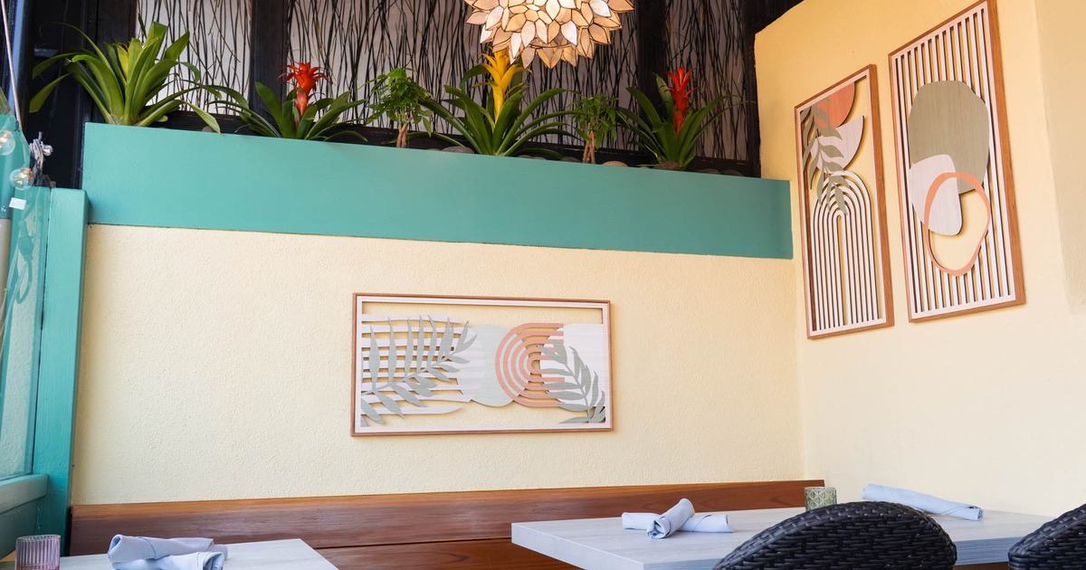 Bright interior with tables, plants, and abstract wall art