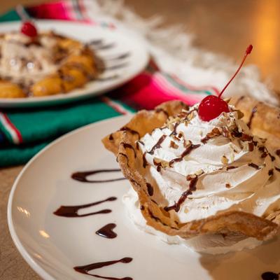 Fried Ice Cream topped with whipped cream and garnished with a cherry.
