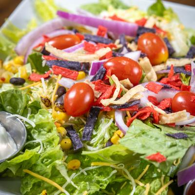 Fiesta salad with lettuce, tomatoes, and tortilla strips.