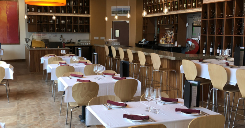 Restaurant interior space, cozy dining area with set tables and bar