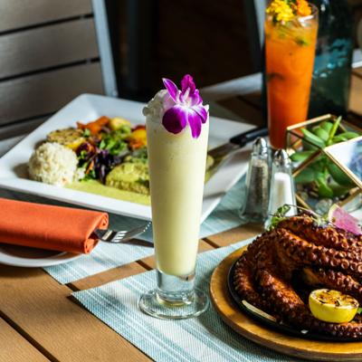 Pina Colada cocktail served alongside other drinks and meals.