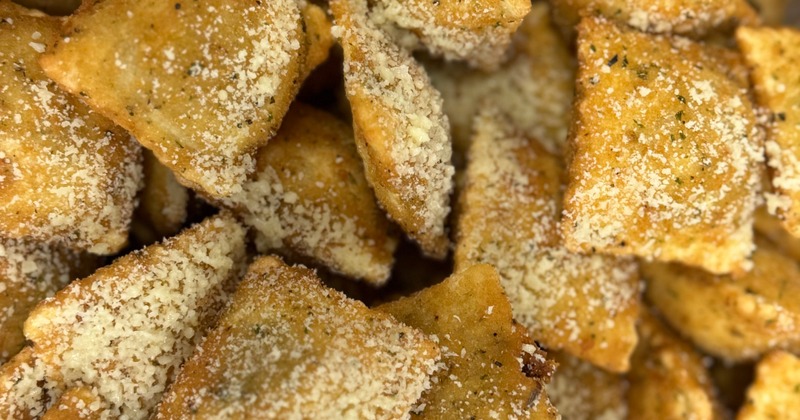 Toasted ravioli covered with grated cheese, close-up