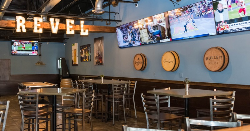 Interior, tables and chairs, tv screens on the wall