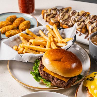Burger with fries and French toast in the background.