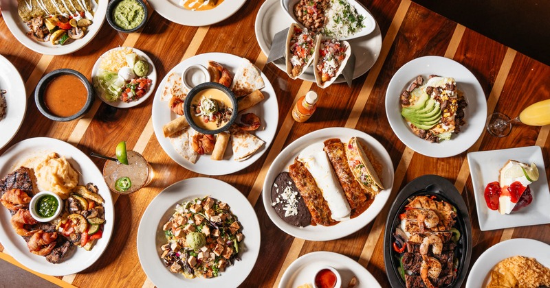 Assorted food plates and drinks arranged on a table, overhead view