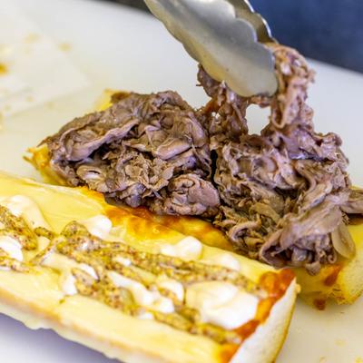 Roast beef sandwich being assembled.