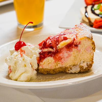 Slice of cake with whipped cream and a cherry.