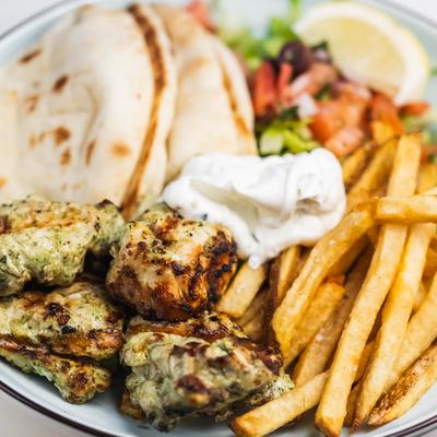 Chicken souvlaki, served with fries, pita, and salad.