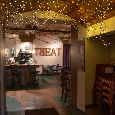 Interior with string lights hanging from the ceiling and wooden furniture.
